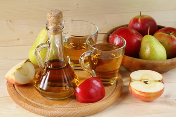 Apple cider and fruit on wooden background.