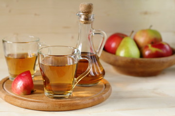 Apple cider and fruit on wooden background.