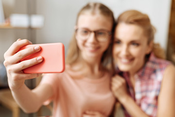 Well-groomed hand of a girl holding a phone