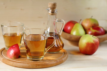 Apple cider and fruit on wooden background.