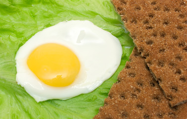 Healthy food background: fried eggs, lettuce, crisp bread