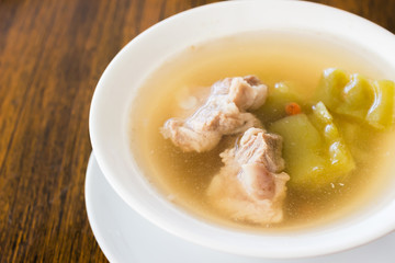 Bitter gourd soup with pork ribs in bowl on wood table