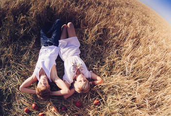 Image of young man and woman lying  on wheat field. Top view