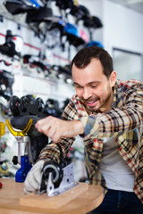 Male master fixing roller-skates in sports store