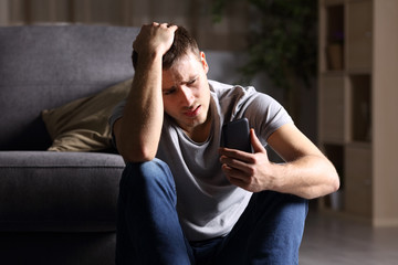 Sad man checking mobile phone - Powered by Adobe