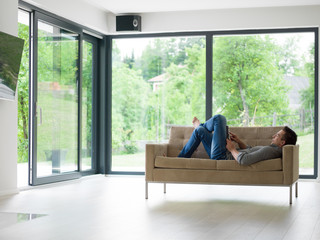 man on sofa using tablet computer