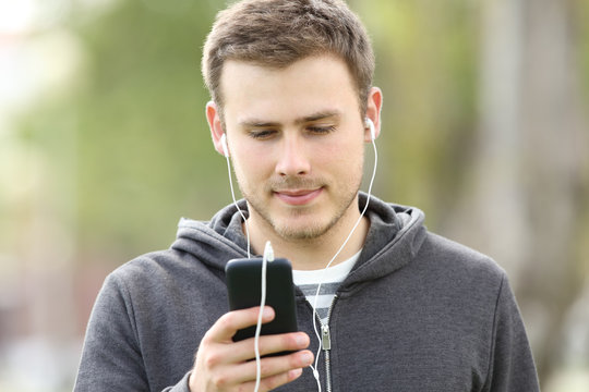 Teen boy listening music with earbuds
