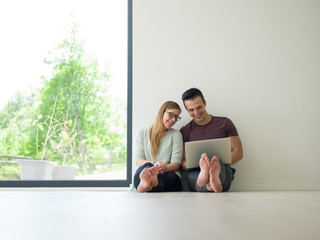 couple using laptop on the floor at home