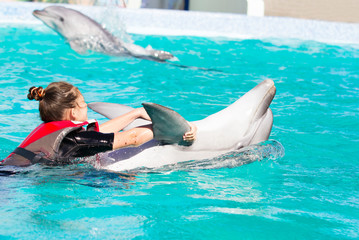 Obraz premium Dziewczyna i delfin pływają razem
