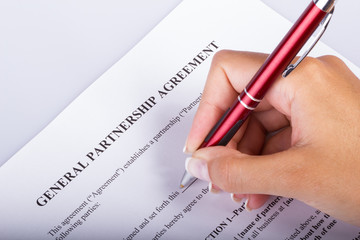 Hand signing a Partnership Agreement, closeup shot for any kind of legal agreements and joint venture deal topics