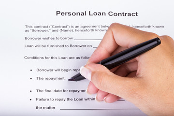 Personal Loan Contract Overview - hand going over the items of the agreement