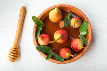 Fresh pears with honey in a ceramic plate.