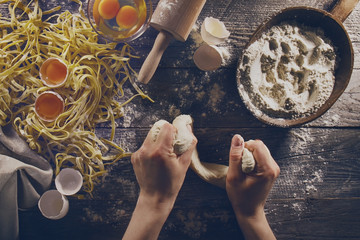 Woman cook hands preparing making tasty homemade classic italian pasta on wooden table. Closeup....