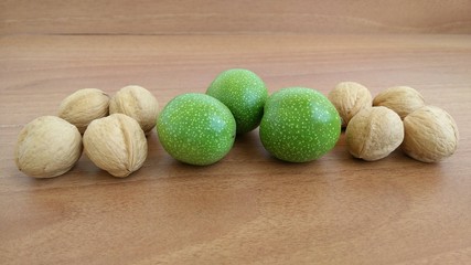 Several ripe walnuts and three green unripe
