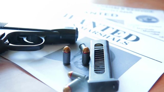 An announcement about the search for a criminal on the table of the bounty hunter, a combat pistol, cartridges