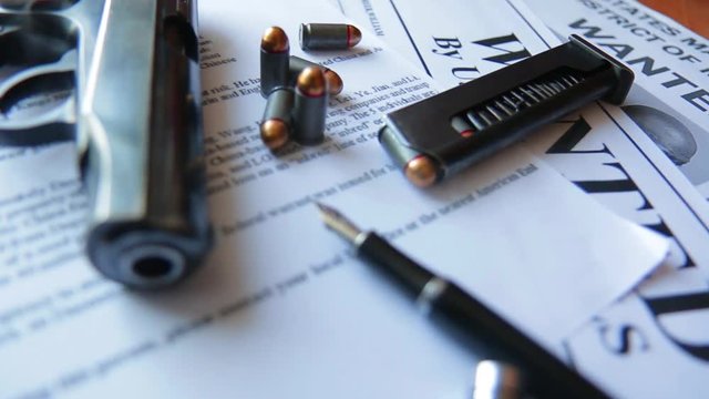An announcement about the search for a criminal on the table of the bounty hunter, a combat pistol, cartridges