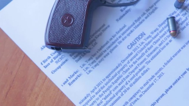 An announcement about the search for a criminal on the table of the bounty hunter, a combat pistol, cartridges