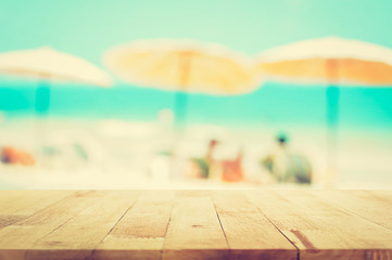 Wood table top on blurred beach background, summer holiday background concept, vintage tone