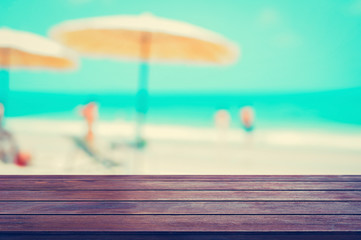Wood table top on blurred beach background, summer holiday background concept, vintage tone