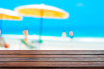 Brown wood table top on blurred beach background, summer holiday background concept