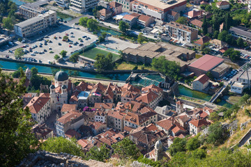 Fototapeta na wymiar Top view of Kotor. Roof tops of old town Kotor: chirch and houses