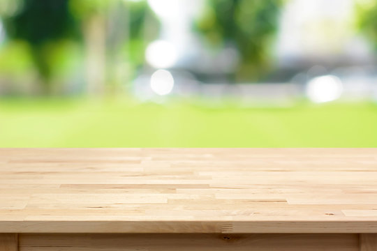 Wood table top on blurred green yard background