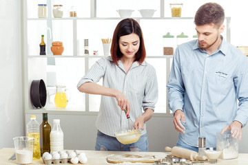 happy Couple in love cooking dough in kitchen
