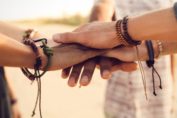 Close up of friends hands holding together