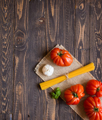Ox heart tomatoes, on rustic wood background, free space for text.