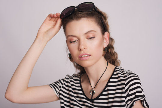 Girl with sunglasses and striped blouse on white background