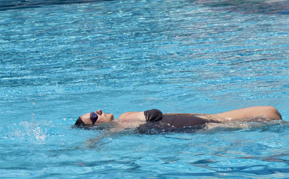 Middle aged pregnant woman swimming in spa pool to relax