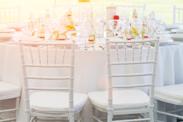 white chairs and fancy table set for a wedding dinner