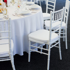 fancy table set for a wedding dinner, white chairs