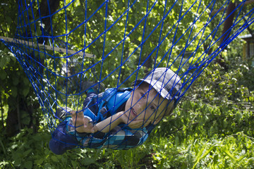 Guy relaxing in the hammock in a wood