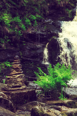 Stone pyramid near a tropical waterfall.