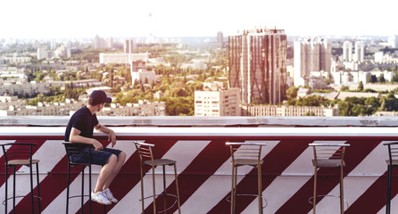Young man on the roof of a tall building