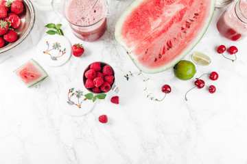 Refreshing watermelon and strawberry lemonade with lime juice, ginger and honey on marble table and white background. Summertime beverage concept. Flat lay with copy space
