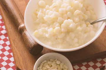 Brazilian dessert sweet canjica of white corn with pacoca sweet in bowl and towel. Festa Junina Party Brazilian Culture Concept Image.