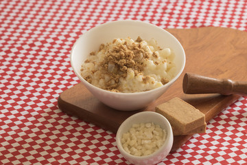 Brazilian dessert sweet canjica of white corn with pacoca sweet in bowl and towel. Festa Junina Party Brazilian Culture Concept Image.