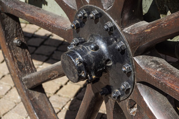 Vintage wooden carriage wheel, straw and street background