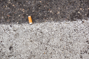 Closeup of a cigarette butt thrown on the pavement