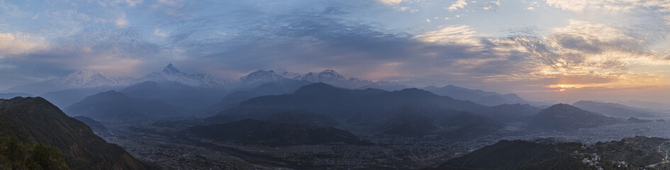 Panoramic view of snow-covered Himalaya peaks of a mountain ridge Annapurna  at sunrise, under the first beams of the sun. 