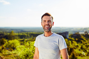 Portrait of happy adult man smiling outdoors - obrazy, fototapety, plakaty