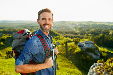 Happy middle-aged man hiking and enjoying the mountain landscape