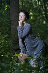 Pretty young girl posing outdoor in a forest