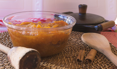 Brazilian dessert sweet of pumpkin, coconut and cinnamon in a bowl and wood table . Festa Junina...