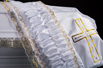 closed wooden white coffin covered with white ritual blanket isolated close-up.