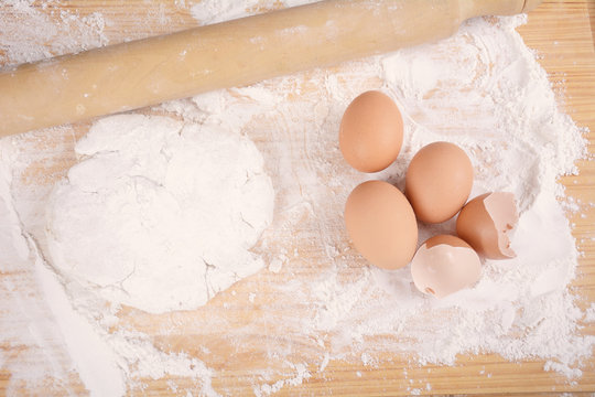 A dough, eggs and rolling pin.