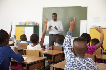 Kids raising hands during a lesson at an elementary school