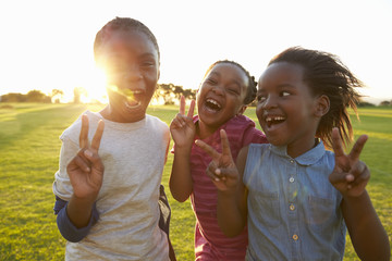 Three African elementary schoolgirls making peace signs